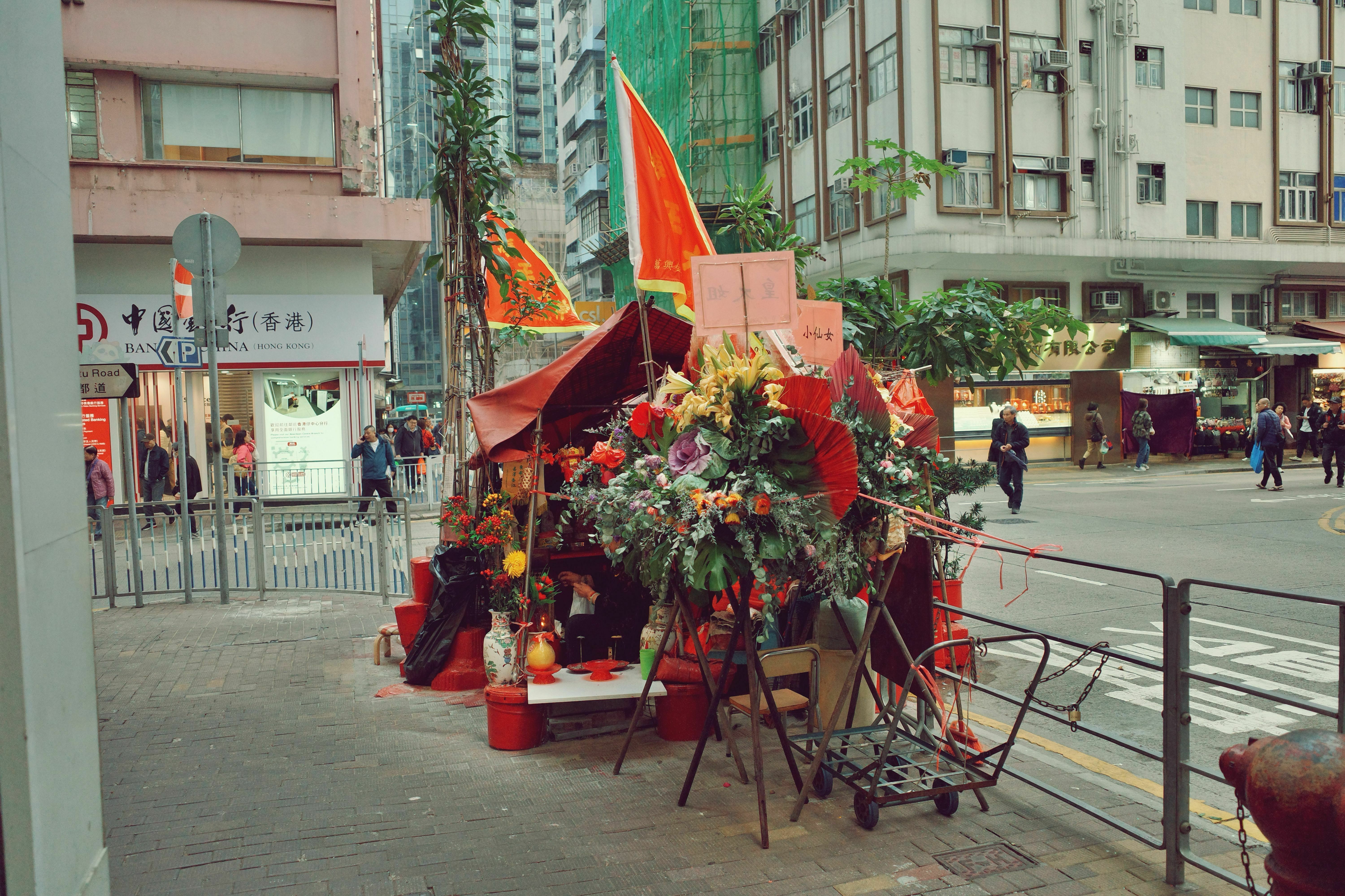 在香港仔中心对面的南宁街，你会看到一个颇具特色的小建筑。乍一看，可能以为这是一个临时摊贩的摊位，但其实这座小建筑是香港仔的海王古庙。海王古庙原本是为渔民们提供庇佑的地方，供奉海神来保护出海的渔民们。然而，由于香港的填海与道路建设，这座庙宇无法被搬迁，最终只能尴尬地“卡”在街道的中间，成为了这个区域的一个独特存在。