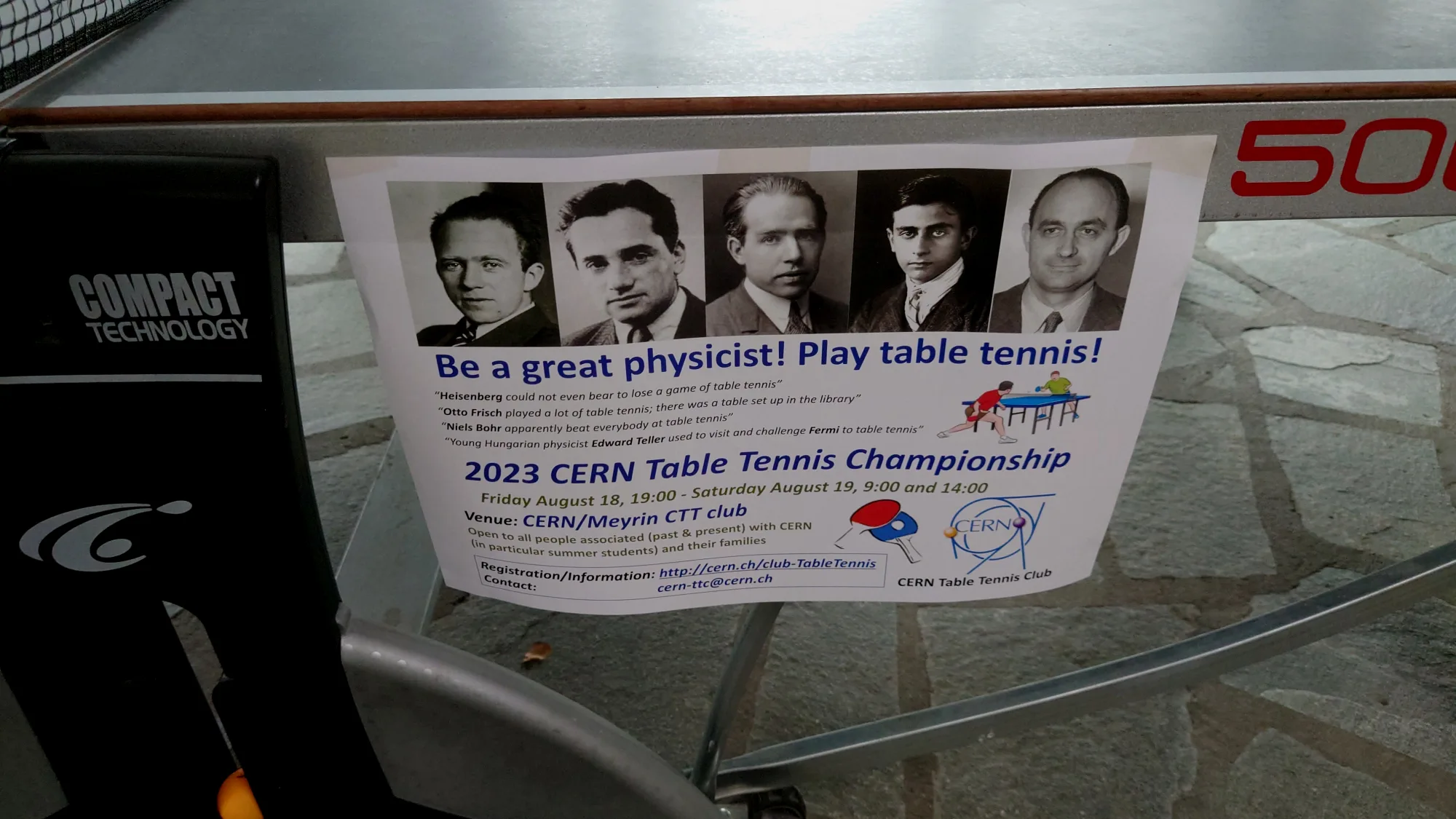 食堂乒乓球桌上贴着的乒乓球赛广告。大意是说玻尔等大物理学家都打得一手好乒乓，所以打乒乓能称为大物理学家，快来加入吧。