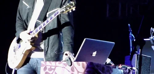 一张截图：Jonny 在2013年的 Open'er 音乐节上。你可以看到笔记本右边的 Scarlett 2i4 USB 声卡（Youtube）。