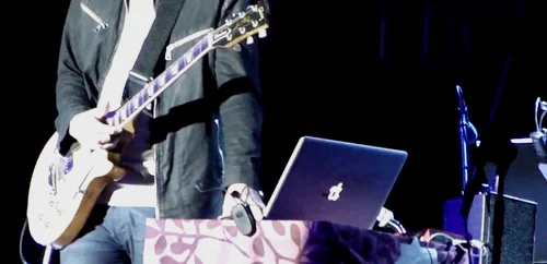 一张截图：Jonny 在2013年的 Open'er 音乐节上。你可以看到笔记本右边的 Scarlett 2i4 USB 声卡（Youtube）。