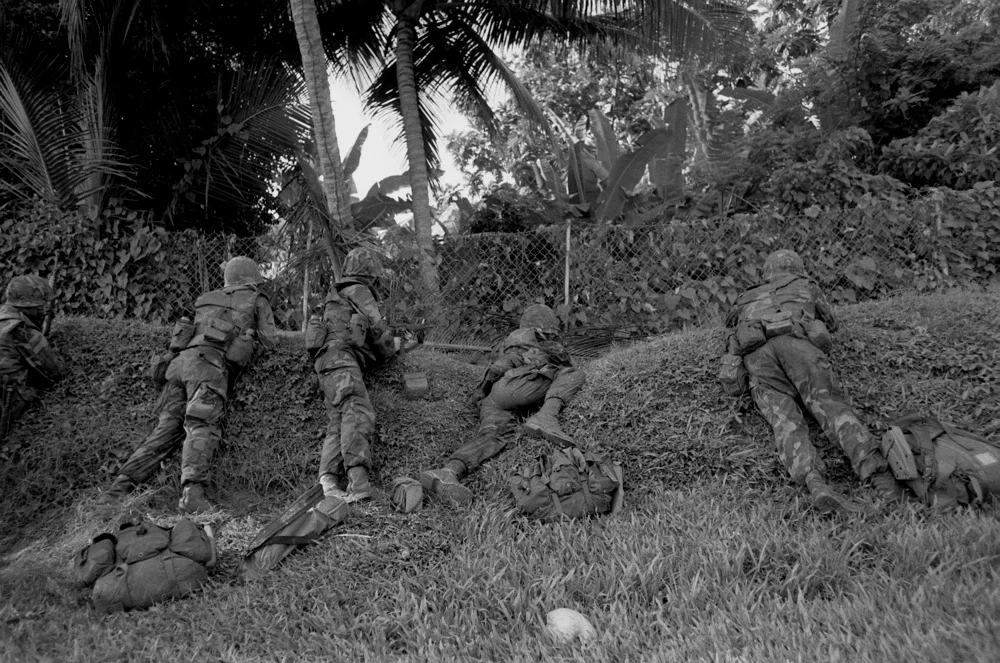 在路边卧倒接敌的一队陆战队员，注意他们的背囊都解脱下来抛在一边