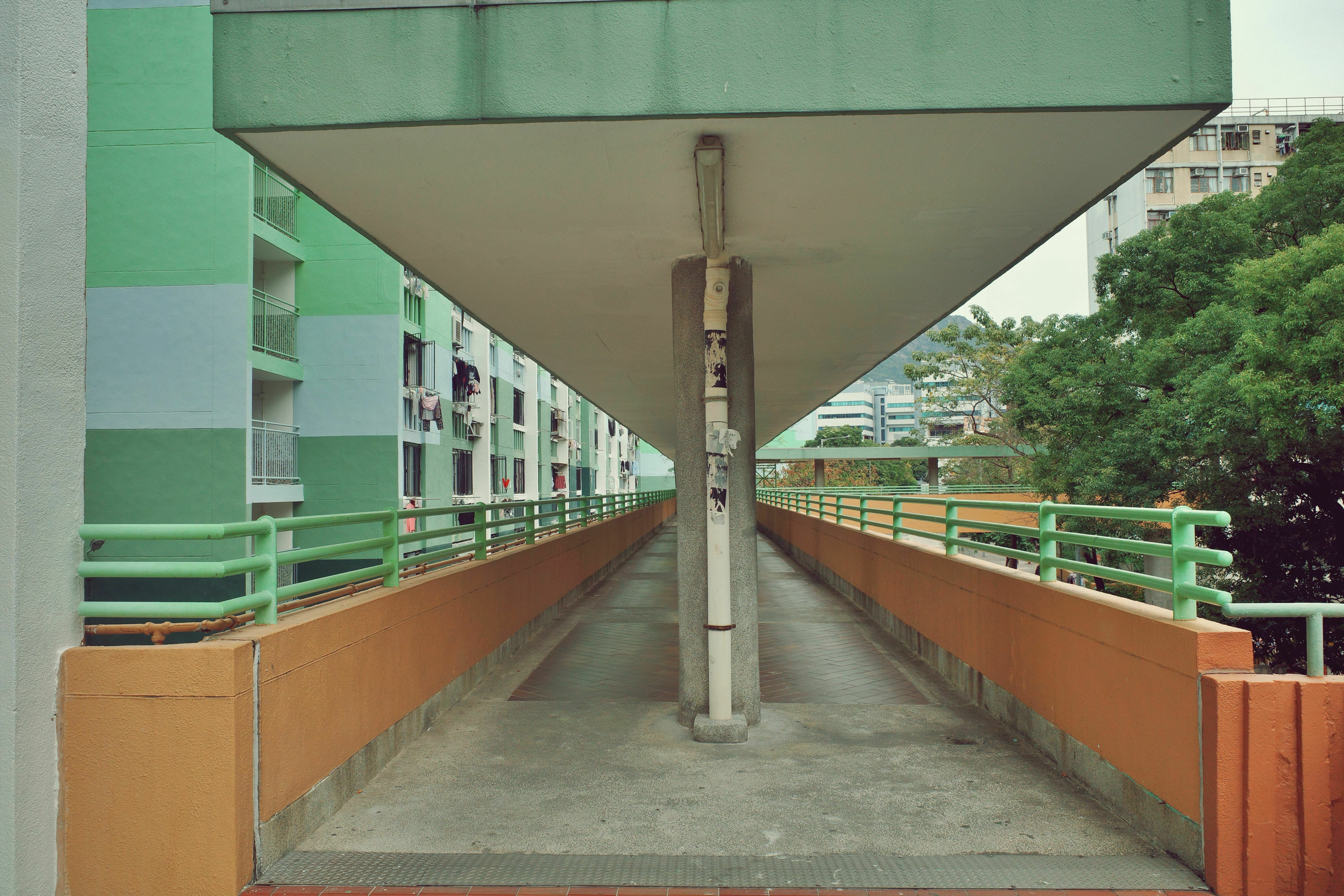 雨棚常常采用混凝土材料，给人一种稳固和坚实的感觉，而这种简约的外观和厚重感外，鲜艳的色彩和简洁的线条往往具有视觉上的亲和力，让这些功能性建筑在城市中看起来不那么单调沉闷。