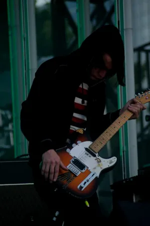照片：Jonny 和他的Telecaster Plus，拍摄于 In Rainbows 巡演期间。请注意拨片被插进了护板里，这也是 Jonny 的小癖好。当他用手指演奏或是演奏别的乐器时就把拨片存在这里，如果拨片在演奏过程中掉了，这也让他可以立刻补上拨片。