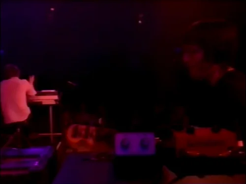 一张截图：Colin 的效果器被放在机架盒顶部。截图来自 Radiohead 于2003年六月5日的 MTV $2 Bill 表演的 Everything In Its Right Place 现场。