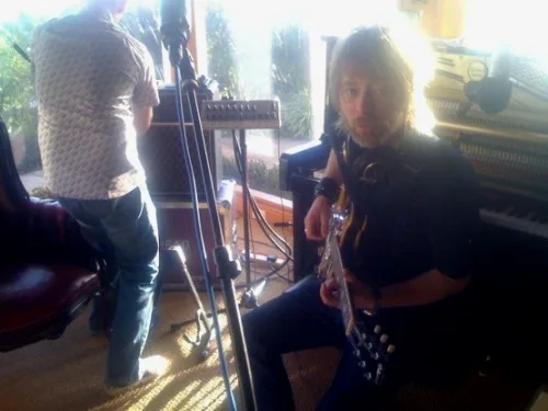 一张照片：The King of Limbs 录制期间，Thom 弹着他的吉他。