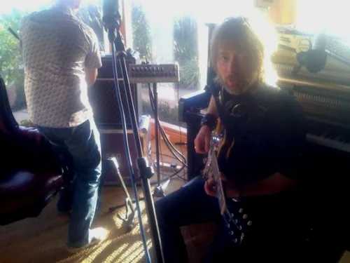 一张照片：The King of Limbs 录制期间，Thom 弹着他的吉他。