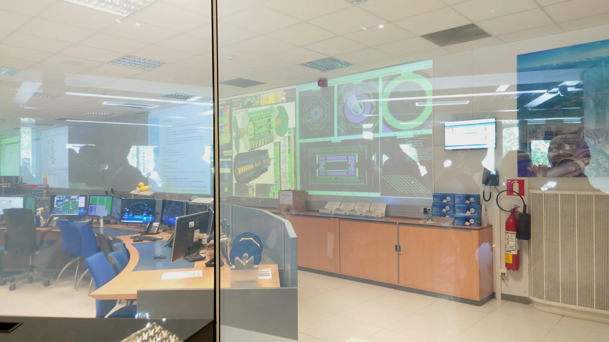 从展览室可以透过玻璃墙看到ATLAS控制室内部。控制室中的大屏幕是用于监控探测器的运行情况，不过由于最近LHC没有在运行，所以没什么人来值班。只有一名安全员按照规定是一定要在里面值班的。
