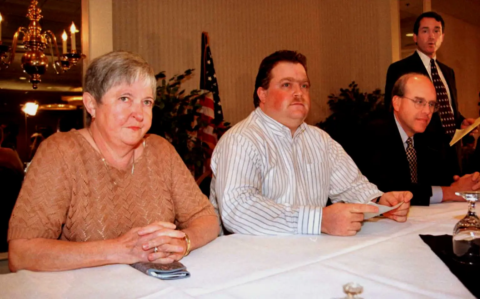 现实中出庭的理查德·朱维尔（中）与他的母亲（左）以及代理律师沃特森·布莱恩特（右二）