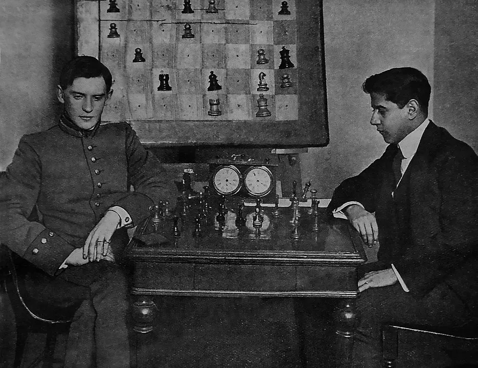 阿廖欣和卡帕布兰卡在圣彼得堡的首次交锋，左侧帅哥即为年轻时的阿廖欣。注意背后的展示棋盘。