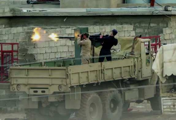 伊拉克士兵坐在一辆大卡车上，用14.5mm口径KPV重机枪射击目标