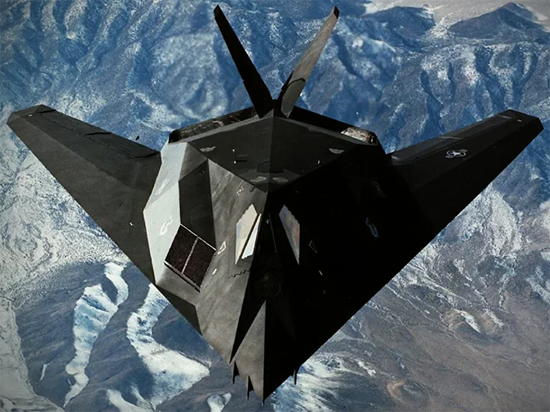 最早的隐形战机——F-117，该机为了保证隐形性能不得不采用了这种怪诞的多边形外观，其控制能力很差，完全不具备空战能力。以至于美国空军放弃了任何为F-117配备空空导弹的计划，将其视为单一的夜间攻击机