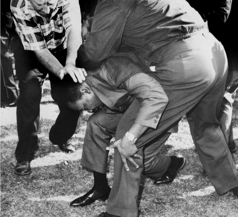 1966年8月5日，芝加哥。被人群投掷的石块打中头部后，马丁·路德·金单膝跪倒在地。