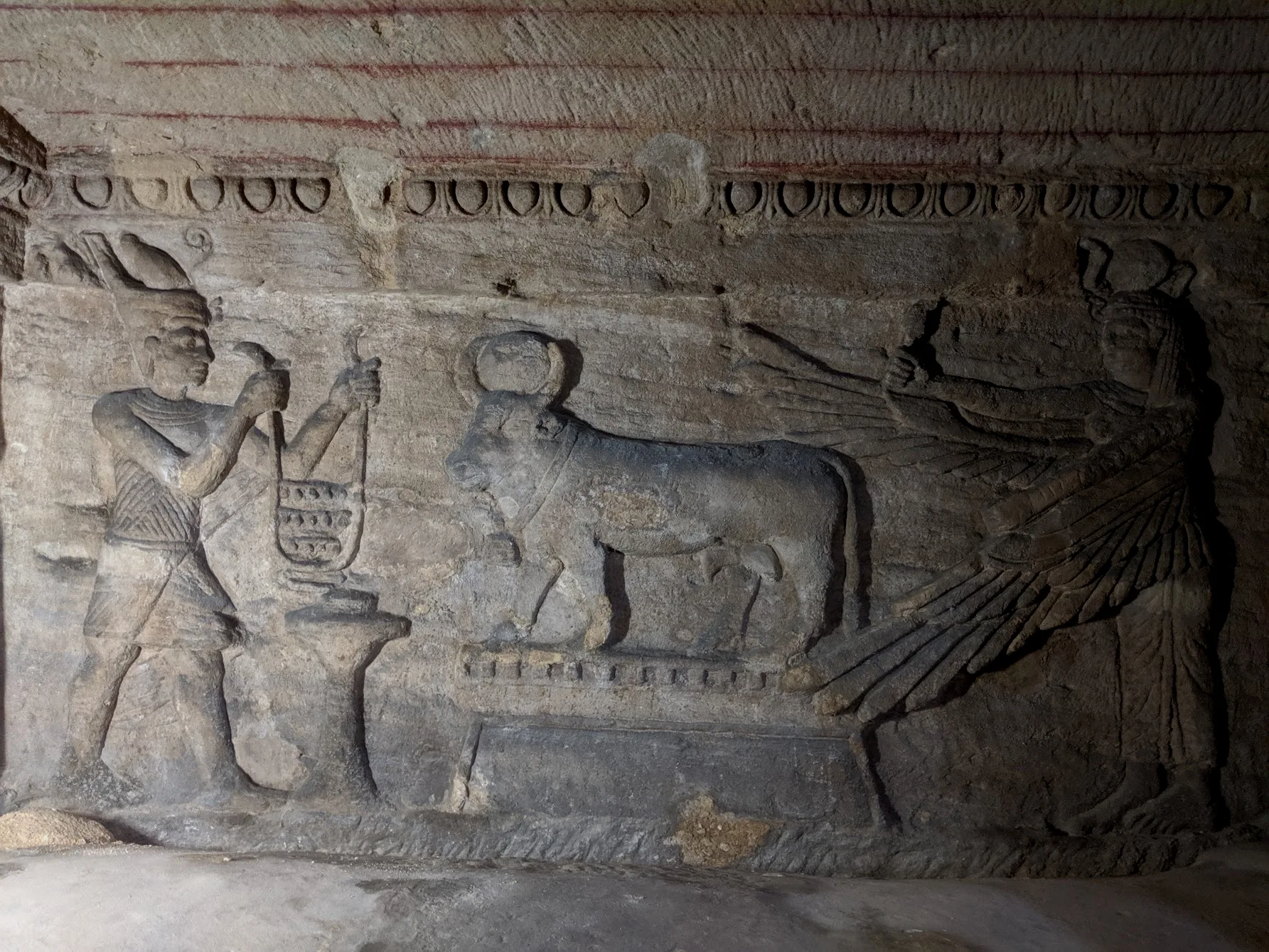 另一处浮雕，左侧或许是法老或人间帝王，右侧是伊西斯，中间的牛是法老之母哈索尔的化身