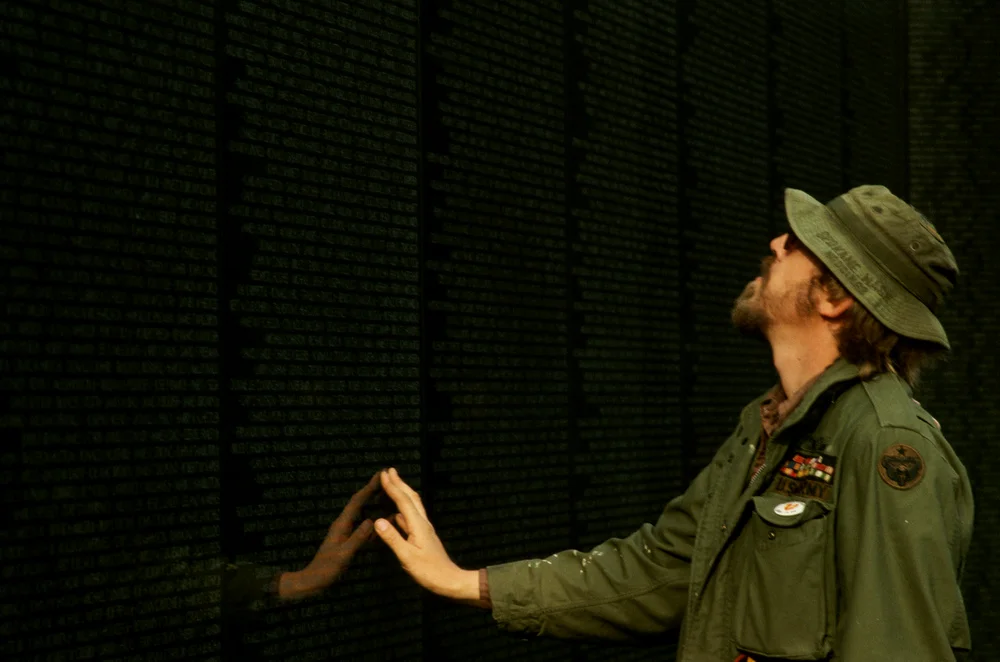 在越战墙前凭悼战友的越战老兵，身穿OG107 M65