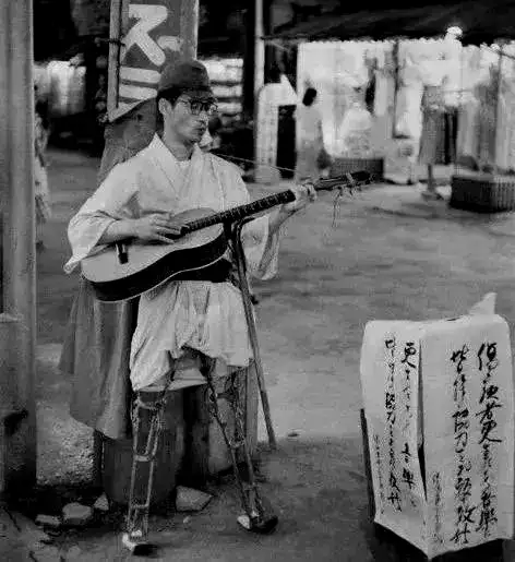 年代不详，约1960年代，在街头卖艺的伤残老兵无人问津，此时的日本军人已不复往日荣光