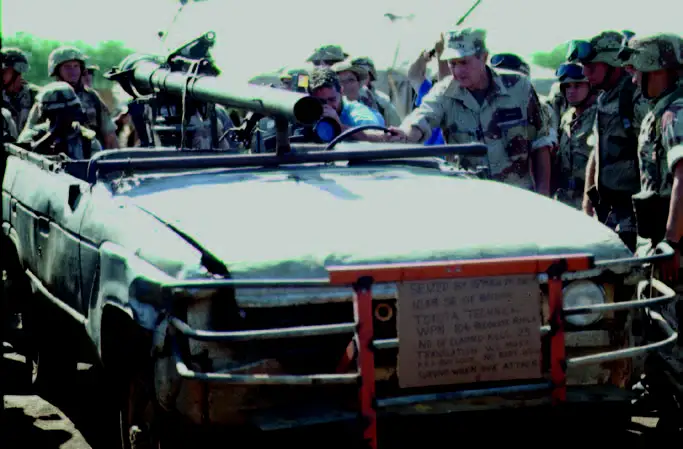 1993年的照片，一辆在索马里被缴获的丰田战车，纸板上的信息说明它使用了106mm无后座炮。拿着方向盘的人眼熟吗？