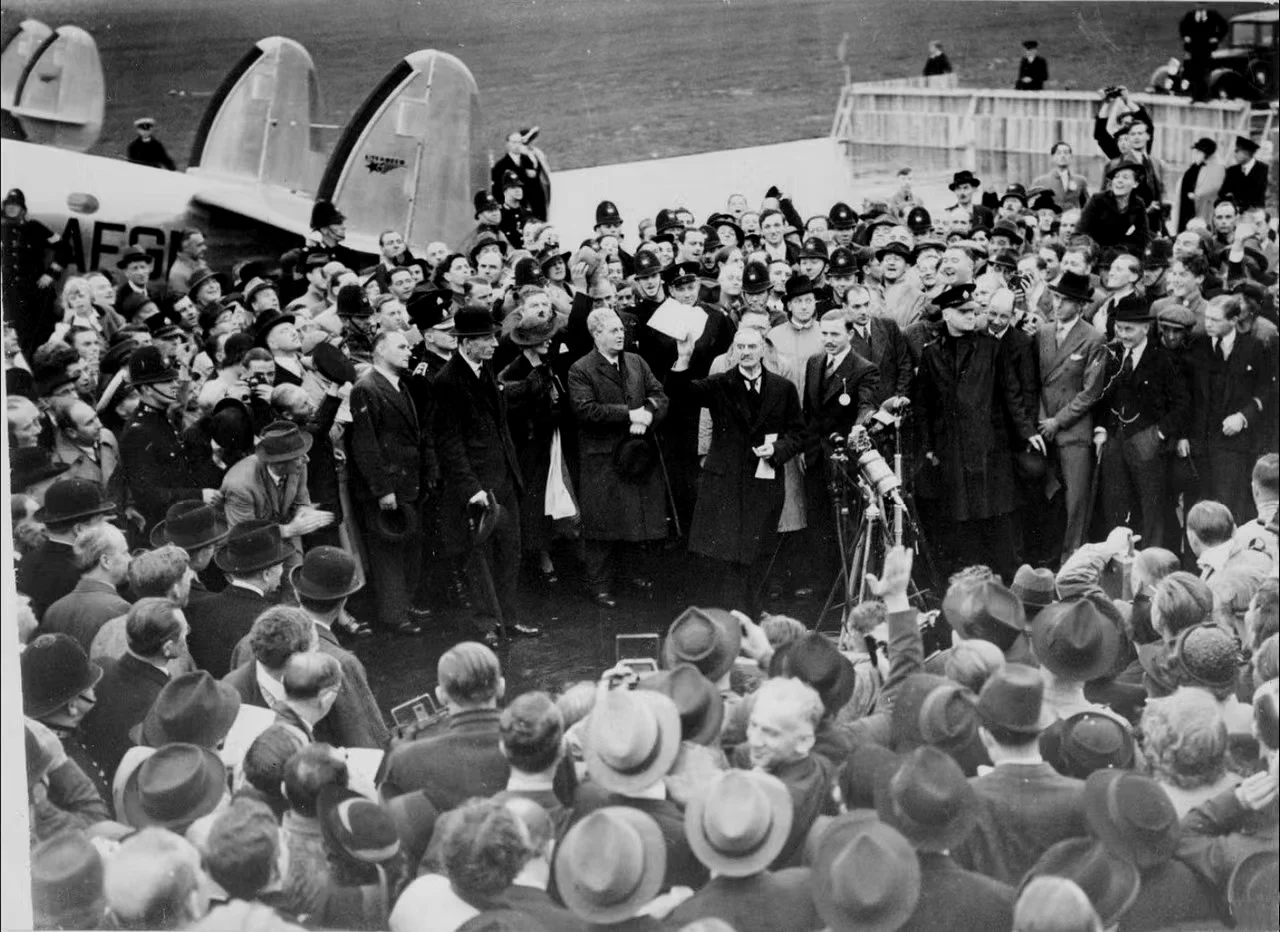 1938年9月30日英国首相张伯伦在机场对群众挥舞著与希特勒签署的和平协定，同时宣称“带回了一代人的和平”。