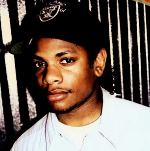Eazy-E，原名埃里克·林恩·赖特(Eric Lynn Wright)，为匪帮说唱(Gangsta Rap)团体N.W.A的原成员之一。Eazy-E出生于康普顿。在早年辍学后靠卖毒品创建了Ruthless厂牌。虽然没有最好的说唱技术，但他的嗓音和歌词却非常特别。